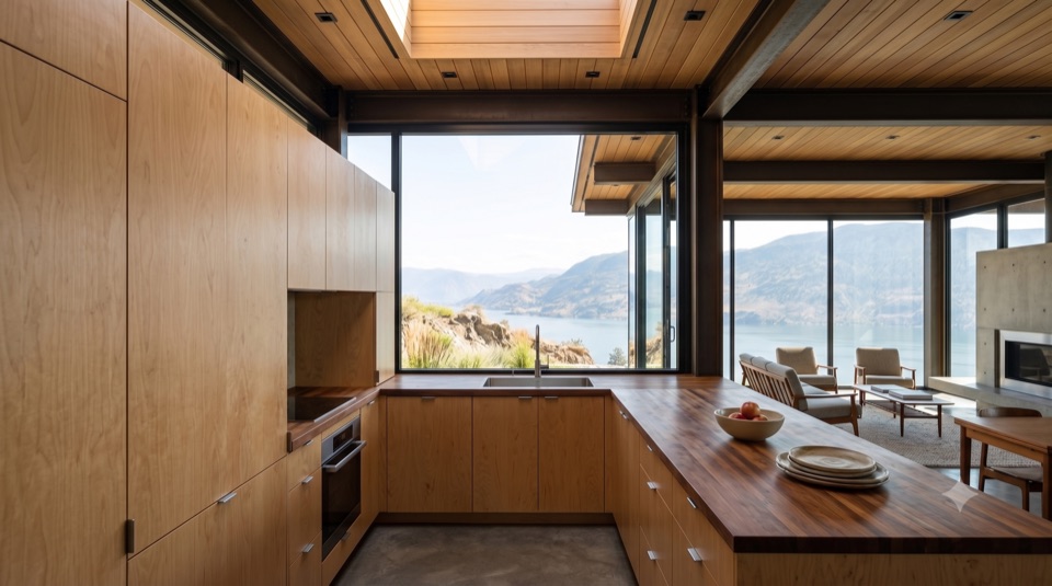 An honest kitchen: plywood, butcher block, a window on the yard.